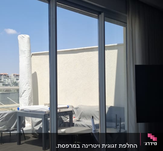 דלתות הזזה מזכוכית בפרופיל דק ביציאה למרפסת